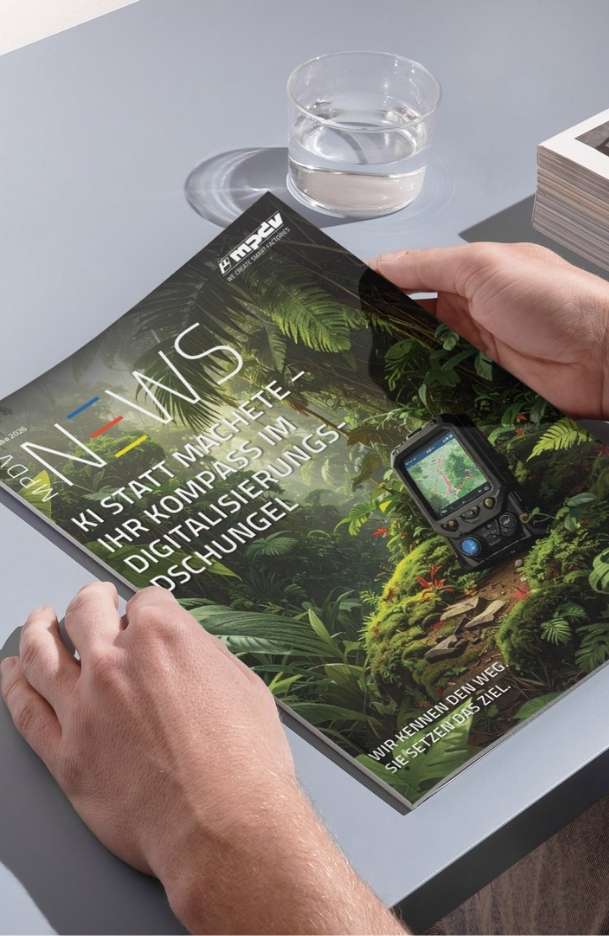 MPDV NEWS Ausgabe 2026 mit dem Titel "KI statt Machete – Ihr Kompass im Digitalisierungsdschungel" auf einem Tisch.