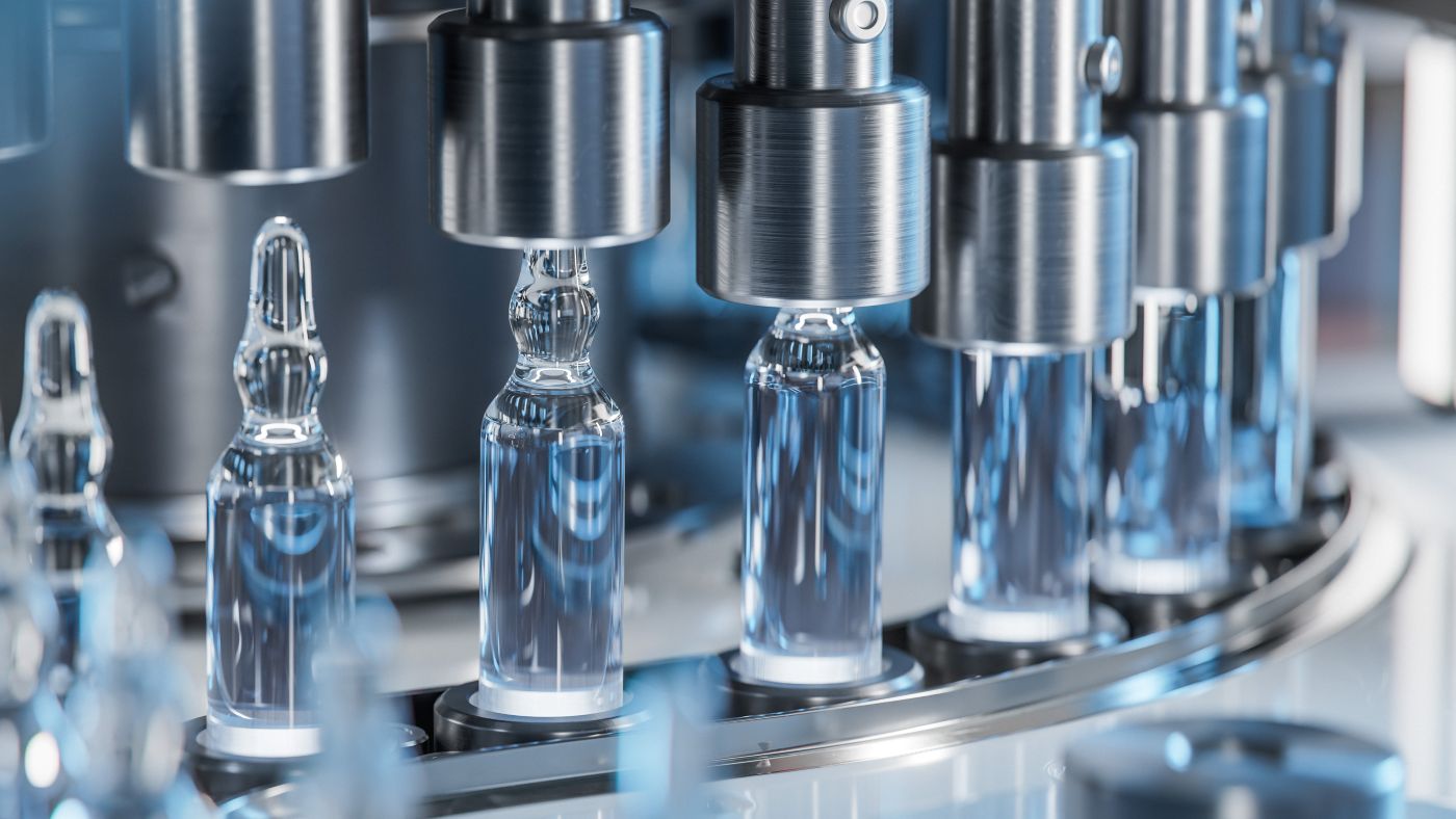 Mehrere Glasampullen auf einer automatisierten pharmazeutischen Abfüllanlage.